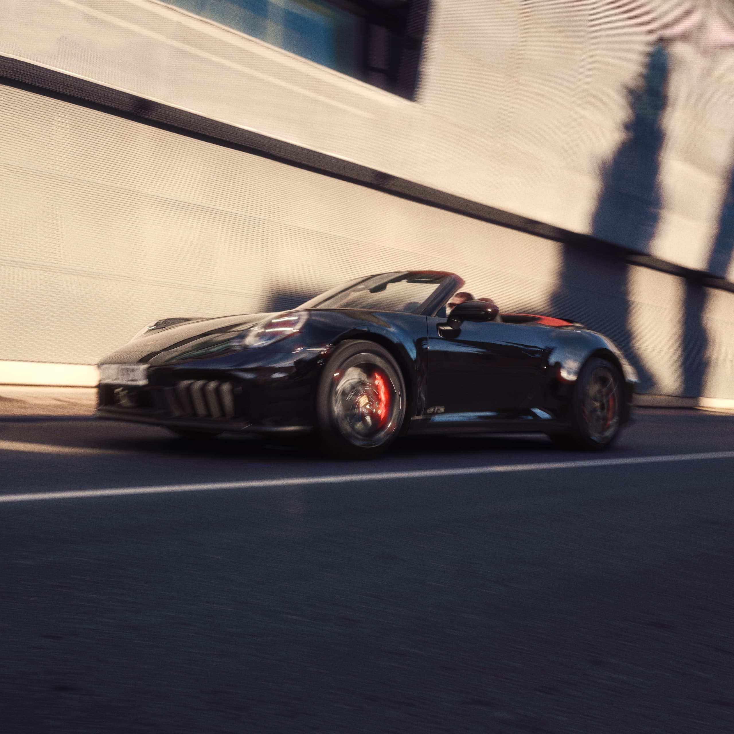 Ein Porsche 911 fährt eine Strasse hinunter.