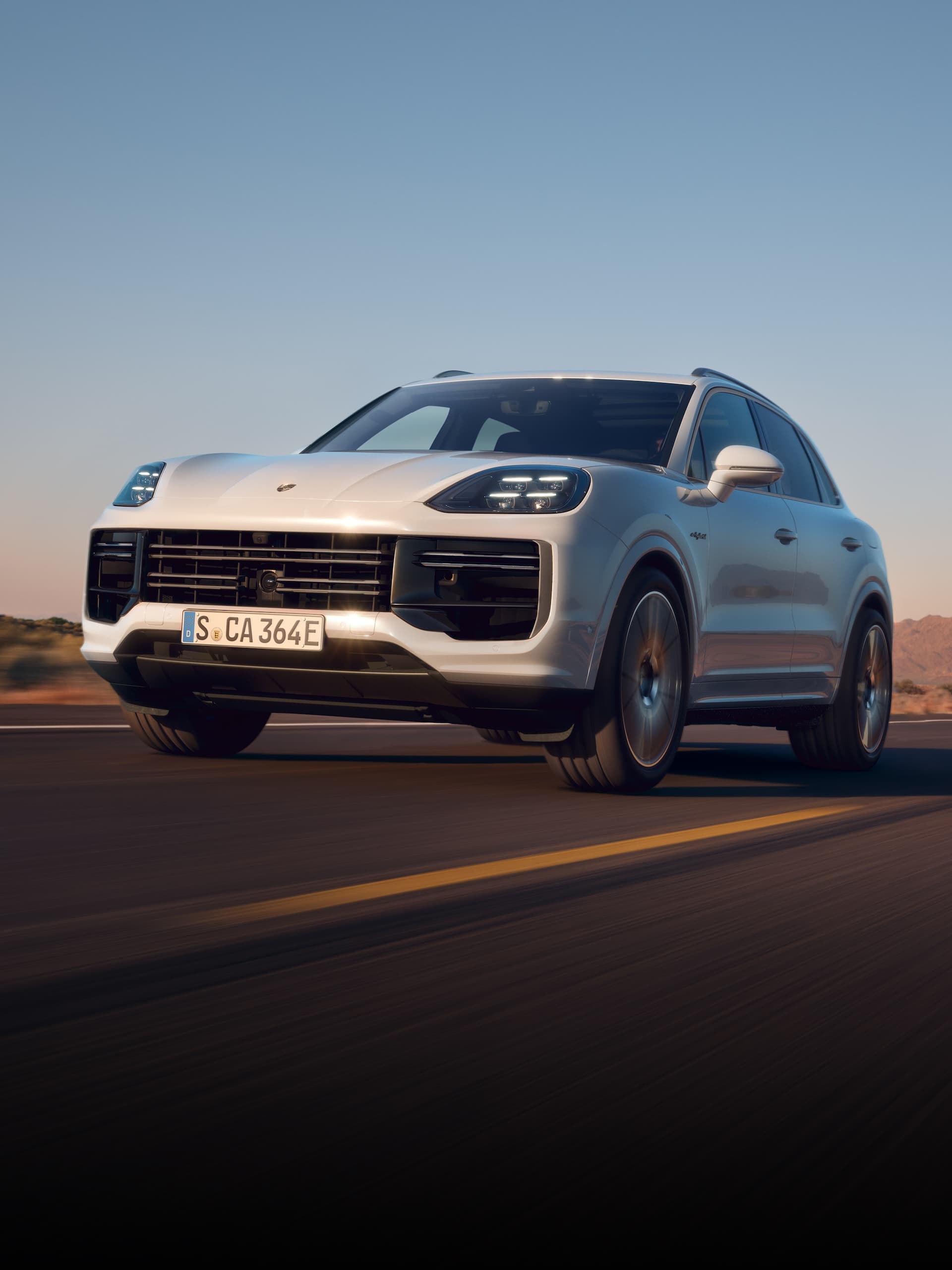 Ein Porsche Cayenne fährt auf offener Strasse.